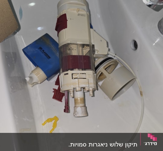 חלקי מנגנון ומצוף של ניאגרה סמויה שהוצאו לצורך תיקון או החלפה